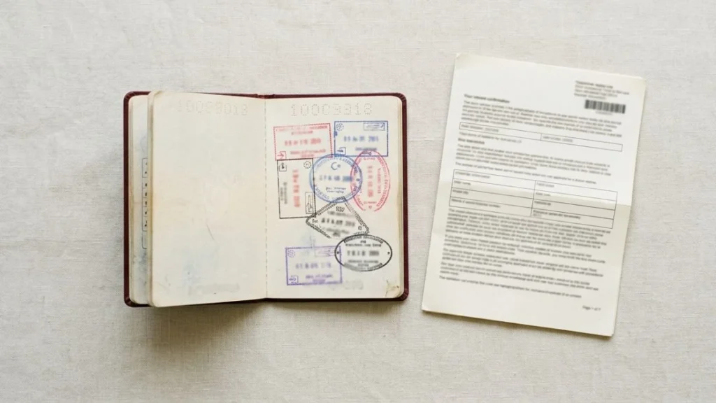 Paspor terbuka dan dokumen visa berdampingan, ilustrasi perbedaan paspor dan visa
